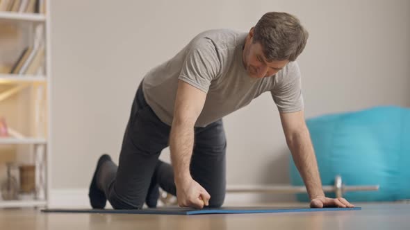 Camera Follows Confident Positive Caucasian Man Taking Sport Position for Pushups and Start alt