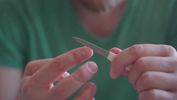 Man Files Nails with a Nail File alt