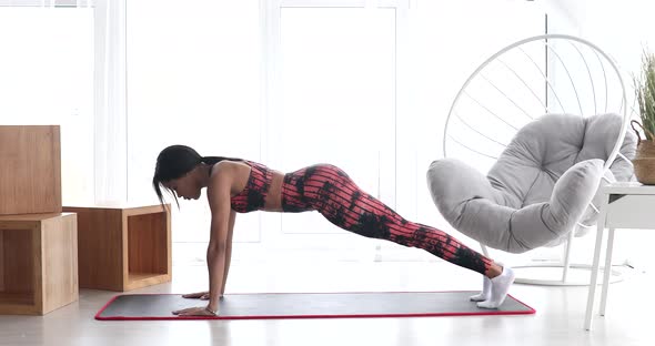 Black woman in sportswear doing workout. Fitness at home.