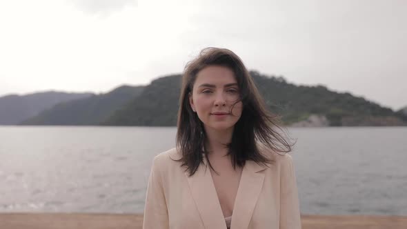 Portrait of beautiful woman enjoying peaceful time at sea pier. Female tourists alt