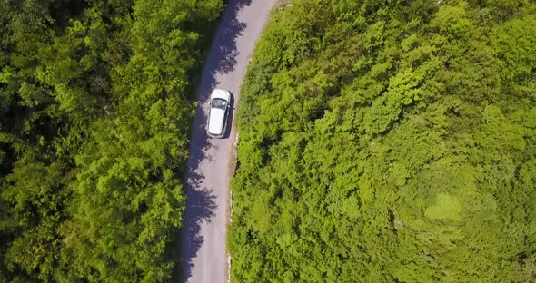 Aerial drone view of a minivan car vehicle driving on a rural road. alt