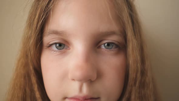 Close Up Female Face of Desperate Child Looking Into Camera Indoor alt