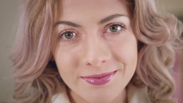 Close-up Face of Beautiful Caucasian Woman with Hazel Eyes and Curly Hair Looking at Camera  alt