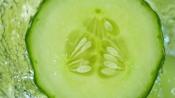 Super Slow Motion Shot of Splashing Water on Rotating Cucumber Slice at 1000Fps alt
