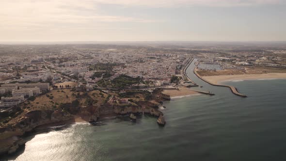 Lagos coastline and cityscape bathed with setting sun light. River mouth and marina. alt