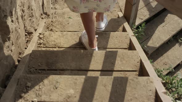Woman Running Down Wooden Stairs to Beach Close Up alt