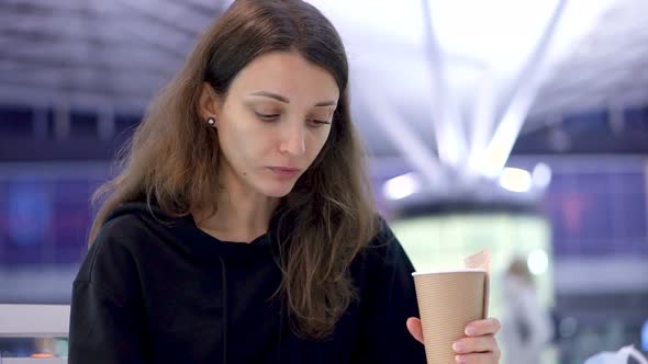 A Girl Holding a Cup of Coffee in Hand alt