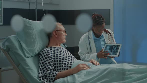 African American Medic Explaining Xray on Tablet to Patient alt