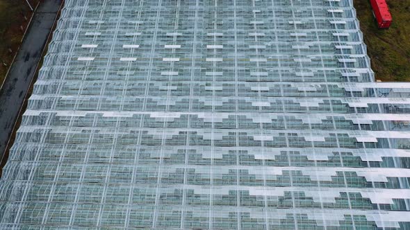 Aerial drone view of large glass windows on the roof of the greenhouse alt