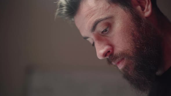 Bearded Man Studying Earnestly, Writing Notes In The Study Room - close up