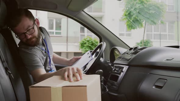 Bearded Courier in Glasses Delivering Parcels To Customer alt