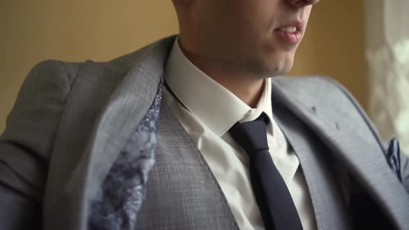 a Man Wears a Jacket and Tie alt