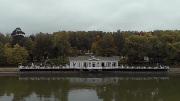 The Camera Flies Over the Water Towards a Beautiful White Restaurant with a Pier Standing Against alt