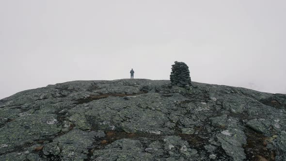 Aerial View Of Hiker Standing On Store Ishaug Mountain Ledge Looking Over Snow Covered Landscape. Do alt