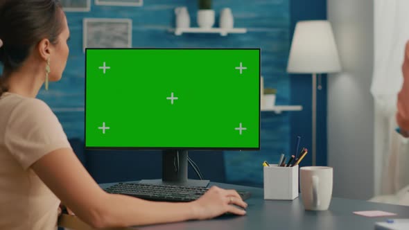 Woman Looking at Computer with Green Screen Mock Up Chroma Key Display alt