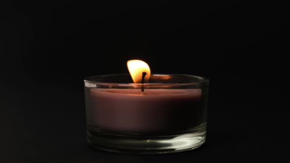 Round Brown Single Candle Flickering in the Dark