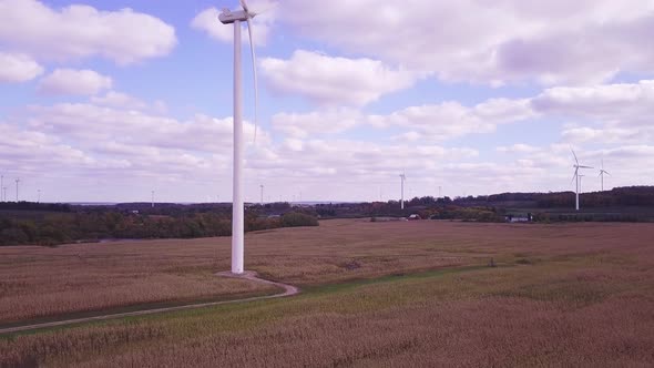 Aerial view of wind turbine creating green and renewable energy.  Camera view is rising in elevation alt