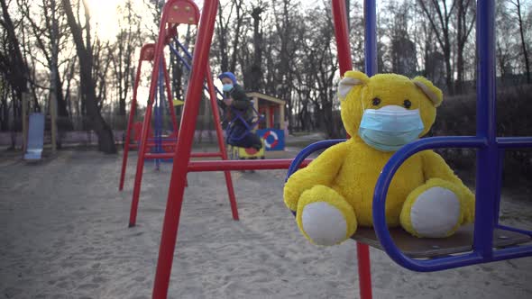 Download Close Up Of Yellow Teddy Bear In Face Mask On Children S Playground With Boy Riding On Swing By Hightfilm PSD Mockup Templates