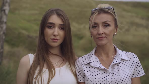 Close-up Portrait of Two Beautiful Confident Caucasian Women with Brown Eyes Looking at Camera and alt