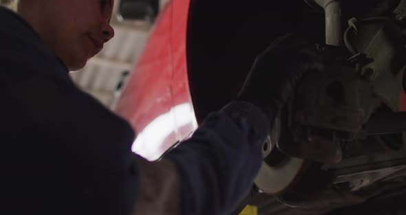 Female mechanic changing tires of the car at a car service station alt
