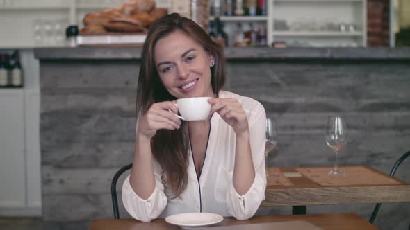 Smiling woman with cup alt