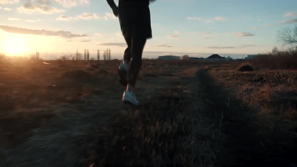 Running Man In Uphill At Sunset.Runner Man Fit Athlete Legs Jogging On Trail Ready To Triathlon. alt