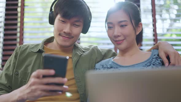 lovely asian marry couple adult stay home lifestyle male playng game smartphone