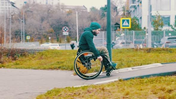 Disabled Man in Wheelchair Makes Attempt To Steer His Wheelchair Over a Ramp on the Street alt