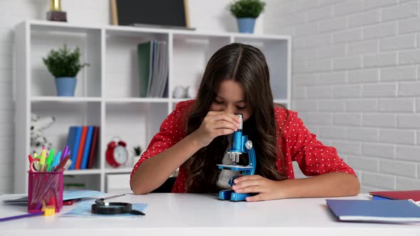 Happy Kid Use Biology Microscope in Classroom School