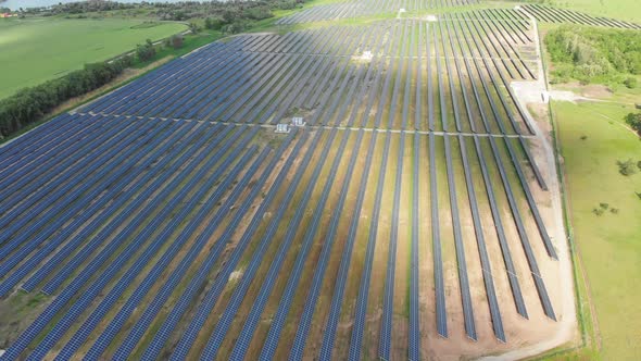 Aerial View on Solar Power Station in Green Field Near River at Sunny Day alt
