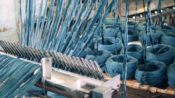 Coloured Yarn is Getting Unwound By a Factory Mechanism alt