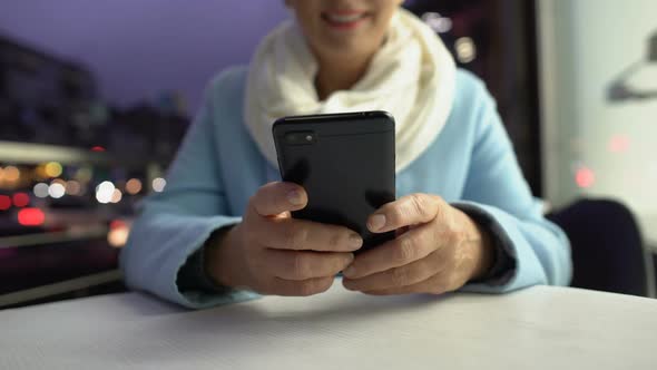 Smiling Lady Scrolling Smartphone Spending Time on Open Terrace of Cafe, Closeup