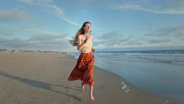 Slow Motion of Young Woman Running By the Ocean and Towards the Camera alt
