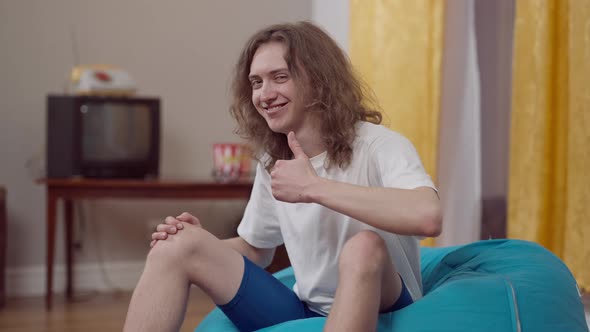 Portrait of Confident 1980s Man Looking at Camera Showing Thumb Up and Smiling alt