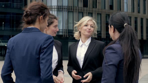 Businesswoman in Suit Talking To Business Female Colleagues or Partners Standing at Office Modern