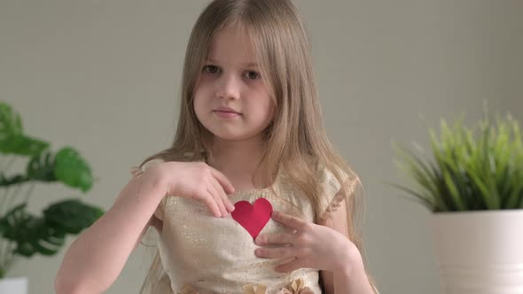 Sad Little Girl Holding Handmade Paper Red Heart for Valentines Day alt