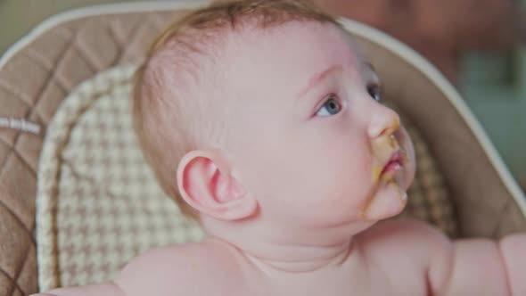 Man father wipes the messy mouth of a toddler baby with a napkin after eating