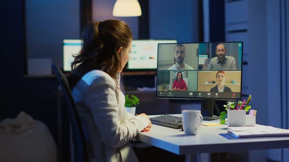 Employee Discussing with Partners Online Using Webcam at Night alt