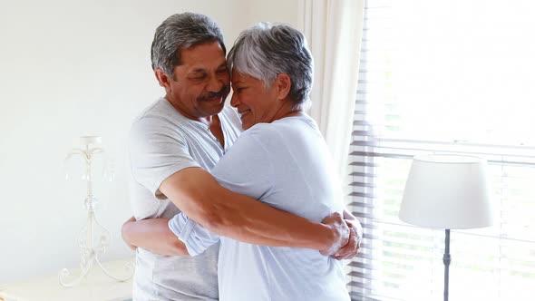 Senior couple embracing each other in bedroom 4k alt