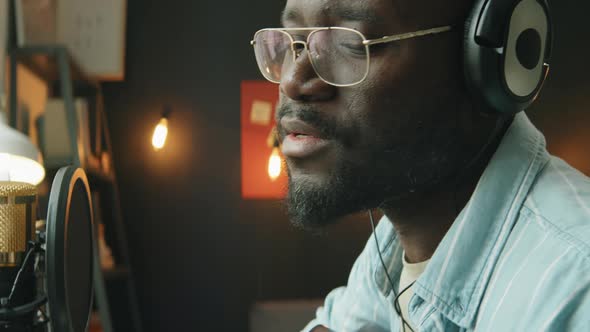 Black Man Playing Guitar and Recording Song at Home Studio alt