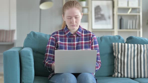 Young Woman Sitting on Couch And Using Laptop alt