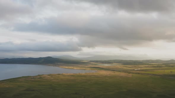 Drone View of a Sunset in a Valley with a River and Mountain Ranges alt
