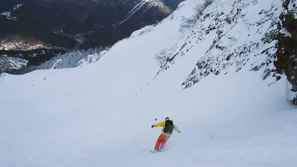 Freerider in a Bright Suit Jumps From a Steep Descent on Alpine Skiing, Slow Motion. alt