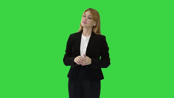 Young Business Woman Presenting Something Pointing at Virtual Objects To Her Sides on a Green Screen alt