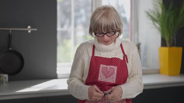 Portrait of Satisfied Slim Senior Woman Measuring Waist Gesturing Thumb Up Looking at Camera Smiling alt