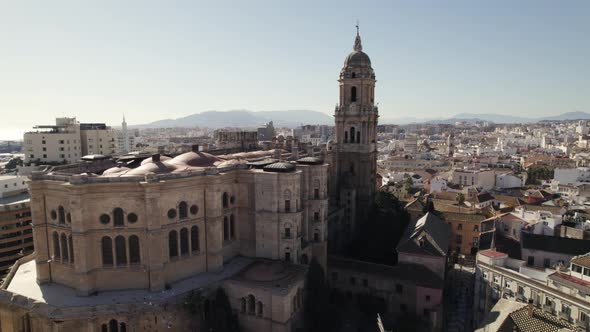 Malaga Cathedral against sprawling cityscape and port. Aerial view