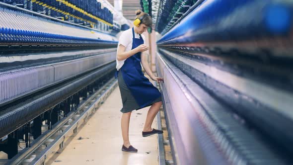 Plant Worker is Adjusting Threads in the Textile Factory Unit alt