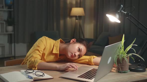 Young Asia Girl Bored While Working From Home At Living Room At Night alt