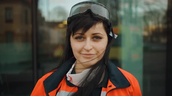 Smiling Female Paramedic with Lowered Respirator Looks at you alt