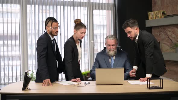 Solid mature man, the director of the company talks to his employees in office alt